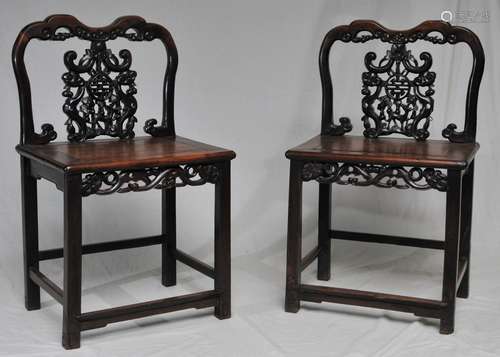 Pair of side chairs. China. 19th century. Carved back splats and aprons. Rosewood. Carving of Ju-i and Shou characters. 21