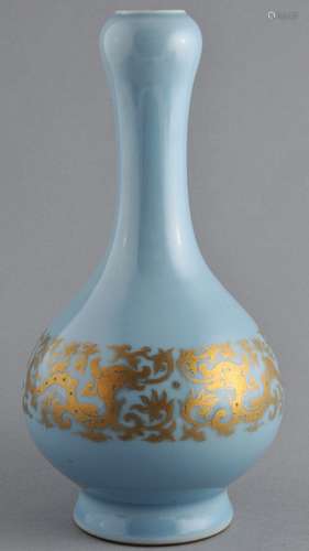 Porcelain vase. China. 19th century. Garlic mouth type. Pale blue glaze with a gilt band of archaic dragons. Red Ch'ien Lung mark on the base. 9