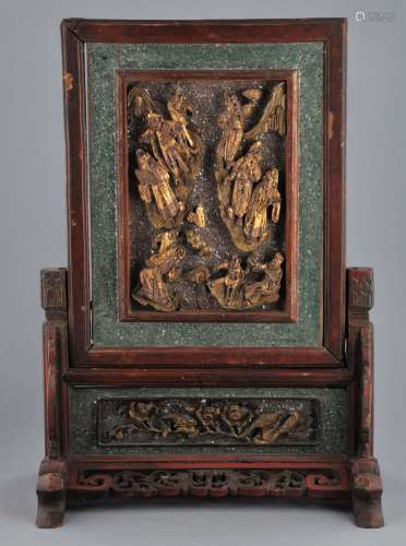 Table screen. China. 19th century. Wood carved with figures in high relief. Surface lacquered red and gold and inset with mica. 22