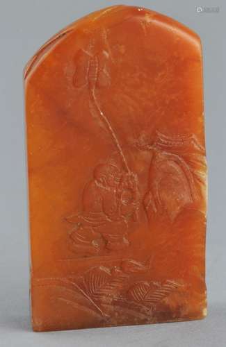 Soapstone seal. Honey coloured stone surface carved with a boy and a butterfly. 3-1/2