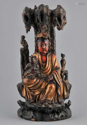 Buddhist Image. China. 19th century. The Goddess of Mercy Kuan Yin with a child seated in a mountain grotto. 12