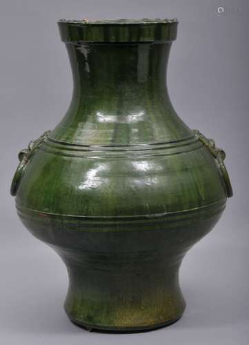 Large pottery jar. China. Han style and possibly of the period. Hu Form with Tao Tieh mask handles with bowstring marks around the body. Forest green glaze with slight iridescence. 18-1/2