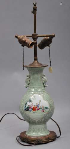 Porcelain vase. China. Early 20th century. Oval baluster form. Famille Rose reserves of children playing on a celadon ground with moulded stylized floral scrolling. Bat shaped handles. Drilled and mounted as a lamp. 11-1/2