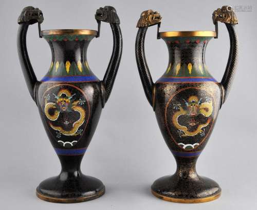 Pair of Cloisonne vases. China. Early 20th century. Pistol grip handles with dragon head finials. Scrolled black ground with reserves of yellow dragons. 11-1/2
