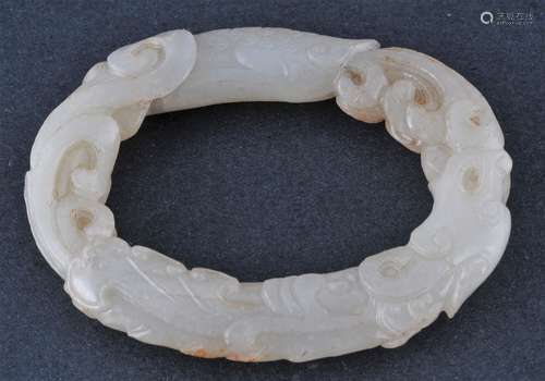 Jade ring. China. 18th century. Greenish white stone. Oval form carved as a feathered dragon. 2-3/4