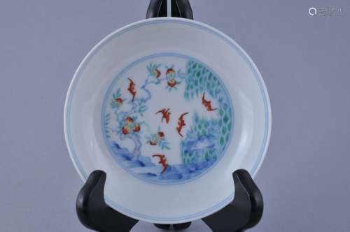 Porcelain saucer dish. China. Early 20th century. Tou Tsai ware. Decoration of a central reserve of bats and a peach tree. Exterior with bats and pairs of fruit with Shou characters. 4-1/2