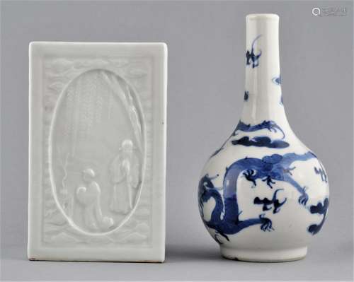 Lot of two porcelains. China. Circa 1900. A bottle shaped vase decorated with dragons and clouds in underglaze blue and a square brush holder with molded decoration and a white glaze. (Ch'ien Lung mark). 5-1/2