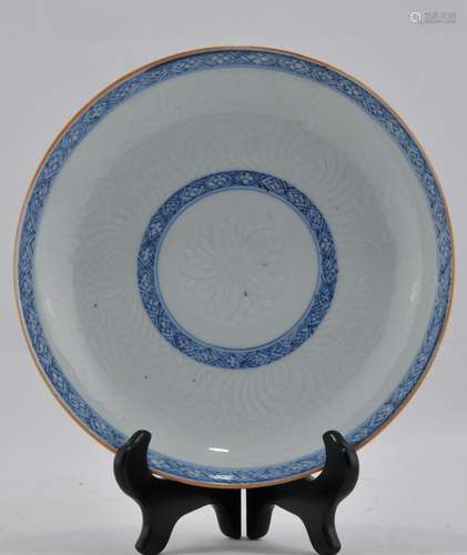 Porcelain plate. China. 18th century. Carved decoration of lotus petals with underglaze blue borders. 8-3/4