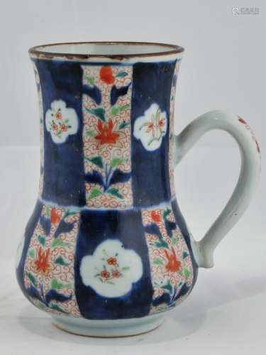 Porcelain tankard. Chinese Export ware. 18th century/ Decoration of underglaze blue with enameled flowers in the Imari palette. Cash coin whimsy in the interior. Fritting on the end of the handle. 6-1/2