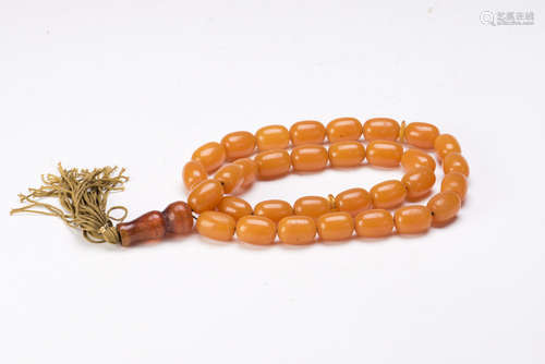 A STRAND OF BEESWAX, 33 BEADS