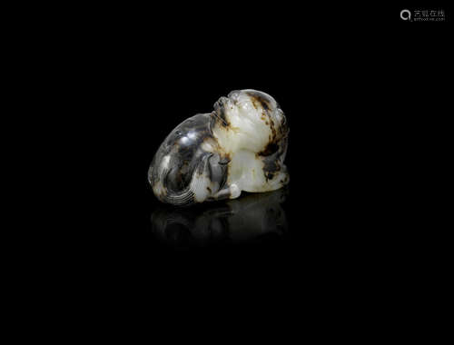 A small black and white jade carving of a Buddhist lion