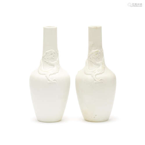 A pair of biscuit 'chilong' bottle vases,Kangxi six-character marks, late 19th/early 20th century