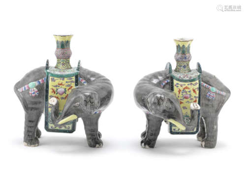 A pair of famille rose models of caparisoned elephants supporting vases,20th century