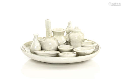 高丽19世纪   青白釉袖珍器皿盘                                                                                                                                          A KOREAN WHITE GLAZED ASSEMBLAGE OF CONJOINED VESSELS ON A CIRCULAR TRAY.