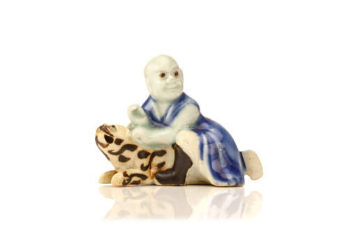 约1750   伏虎罗汉瓷像                                                                                                                                           A CHINESE PORCELAIN FIGURE OF PINDOLA WITH A TIGER.