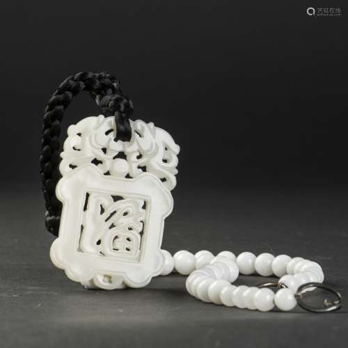 A WHITE JADE PLAQUE WITH A STRING OF JADEITE JADE BEADS