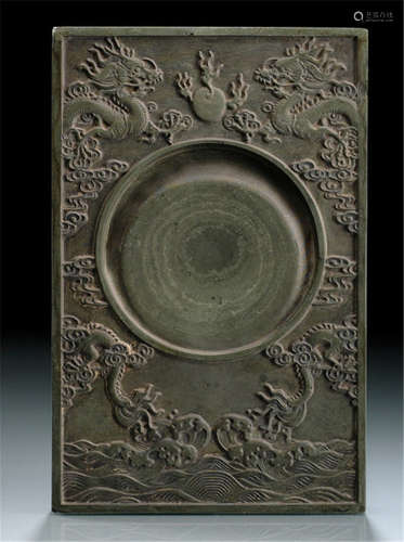 A DECORATIVE INK STONE DEPICTING MIRRORING DRAGONS AND FLAMING PEARL