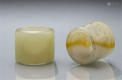 TWO ARCHER'S RINGS, China, Qing dynasty - Jade, one ring with archaistic relief, the other plain - Traces of use