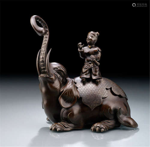 A SILVER-INLAID BRONZE KORO, Japan, Meiji period, in the shape of a reclining elephant with a long raised trunk, silver inlaid cover with starry pattern surmounted by a figure of a seated karako - Minor wear, one attribute of the karako lost