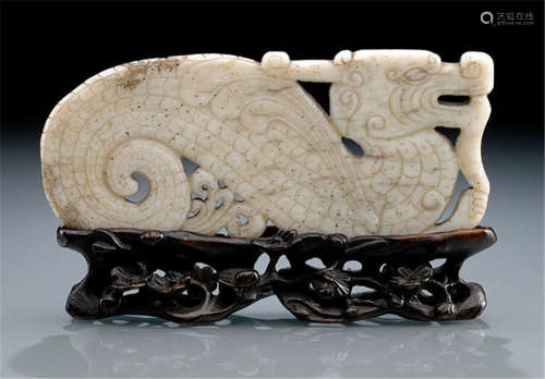A JADE CARVING OF A STYLIZED DRAGON, WITH WOOD STAND, China, 17th/18th ct