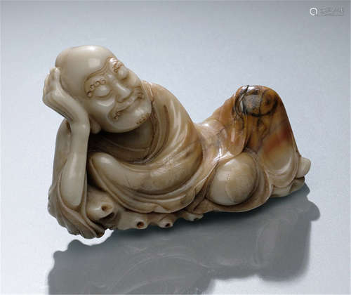 A FINE CARVED SOAPSTONE MODEL OF A RECLINING LOUHAN, China, early Qing dynasty-Property from a German private collection-Rest