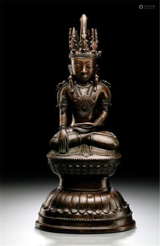 A BRONZE FIGURE OF BUDDHA SHAKYAMUNI, Burma, Shan-Periode, 18th Ct., seated in vajrasana on a lotus base with his right hand in bhumisparshamudra while the left rests on his lap, wearing samghati, bejewelled, his face displaying a serene expression with downcast eyes, elongated earlobes with large ear-ornaments, his hair combed in a chignon and secured with a tiara - Provenance: Property from an old German private collection, purchased from Bernheimer in Munich in the 1930's, since then in possession of the family of the current owner - Minor wear, chipped