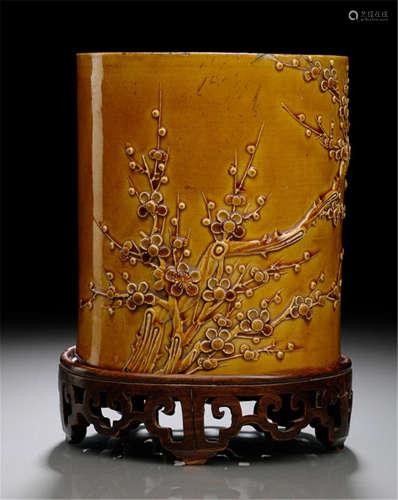 A YELLOW-GLAZED MOLDED PORCELAIN BRUSH POT WITH A FLOWER BRANCH