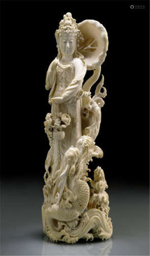 AN IVORY OKIMONO OF KANNON STANDING ON A DRAGON, Japan, signed Gyokuren, Meiji period, finely carved, holding a basket with flowers and carrying a straw hat on her back - Provenance: Purchased from Kunst- und Auktionshaus Reimann & Monatsberger, Stuttgart, 29.06.1985, Nr. 1112 - Minor fine age cracks, slightly chipped and rest.