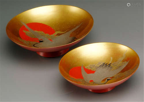 TWO LACQUER SAKE CUPS, Japan, signed, Meiji period, decorated with cranes in flight in front of a red sun surrounded by clouds - Property from an old German private collection, acquired before 1990 - Minor wear, one stand with tiny chip