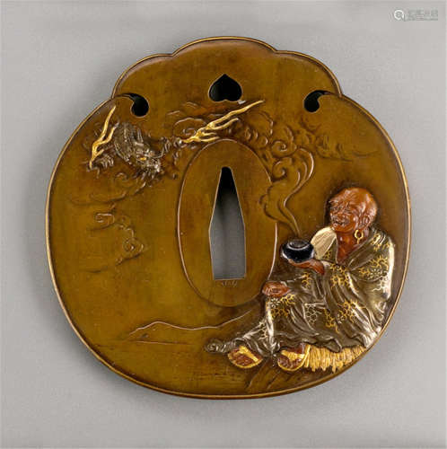 A FINE SENTOKU TSUBA, Japan, signed Tankasai Motoaki saku, late Edo period, the front decorated with seated Handaka Sonja and the dragon emerging from the bowl, the back incised with rocks and a waterfall - Formerly property from an old Berlin private collection - Minor wear, old engraved collector's number at the front