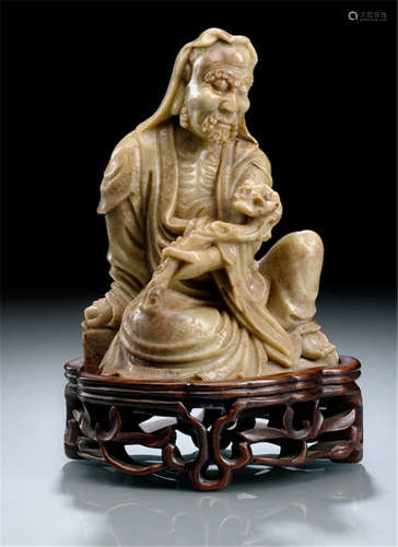 A SOAPSTONE CARVING DEPICTING A BODHIDHARMA HOLDING A RUYI SCEPTRE