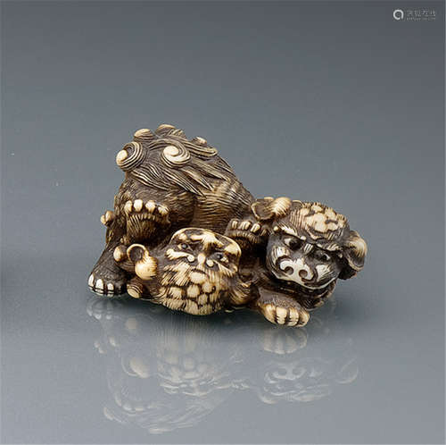 AN IVORY NETSUKE OF TWO SHISHI, Japan, 19th Ct., two shishi finely carved engaged in a friendly romp  - Former property from a European private collection - Minor wear, one paw re-placed