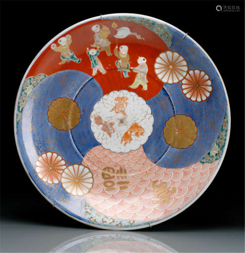 AN IMARI DISH DECORATED WITH BOYS AT PLAY AND STYLISED WAVES