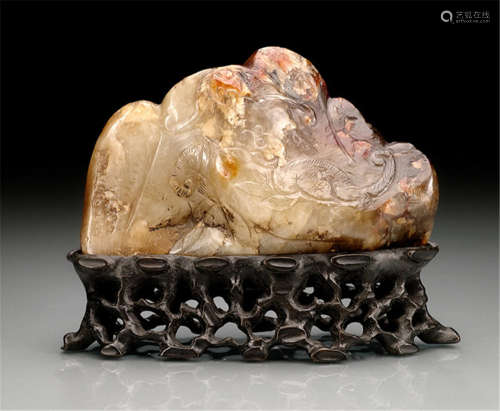 A JADE CARVING OF A SCHOLAR'S ROCK ON CARVED WOOD STAND