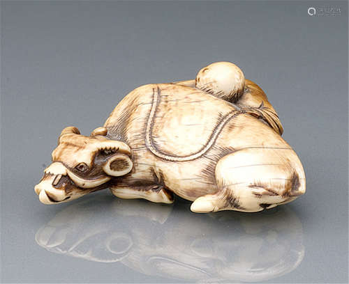 AN IVORY NETSUKE OF A RECUMBENT OX AND BOY, Japan, incised Tomotada, 19th ct. - Former property from a European private collection - Some wear