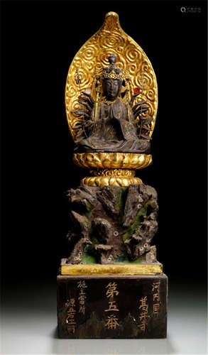 A PARCEL-GILT WOOD FIGURE OF KANNON, Japan, Meiji period, seated with legs crossed on a lotus base placed on a rock-formation set on a rectangular base, the principal hands in anjalimudra while the others radiate around her body, her principal face displaying a serene expression with downcast eyes and a mandorla behind, the base with inscription: Kawachi-kuni shôji daigoban seshu tôsho Minamoto Gouemon - Property from an old South German private collection, collected between 1960 and 1980, by inheritance to the present owner - Slightly damaged due to age