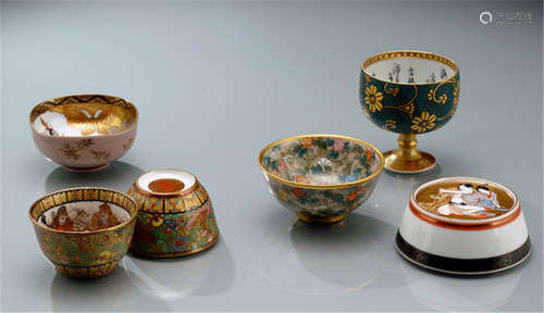 A GROUP OF FIVE VARIOUS SMALL KUTANI PORCELAINS, Japan, marked: Kutani Ihei; Kaga-kuni Kutani zô; Kutani Taniguchi und Kutani, Meiji, a stem cup with floral decorations, a pair of bowls depicting the seven gods of fortune, one bowl with floral decoration and one with shunga scene hidden under the base - Minor wear