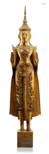 A GILT-BRONZE FIGURE OF THE BUDDHA PAREE, Thailand, Ratnakosin period, 19th Ct., standing in samabhanga with both hands in abhayamudra, wearing samghati, bejewelled, pair of shoes, his face displaying a serene expression with mother-of-pearl inlaid eyes and his head topped with a pointed crown - Property from an old Bavarian private collection, acquired between 1960 and 1990 - Traces of age, mounted