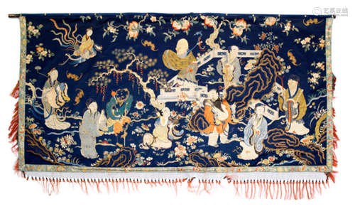A FINE EMBROIDERY PANEL DEPICTING IMMORTALS ON A GARDEN TERRACE SET AGAINST A DARK BLUE GROUND
