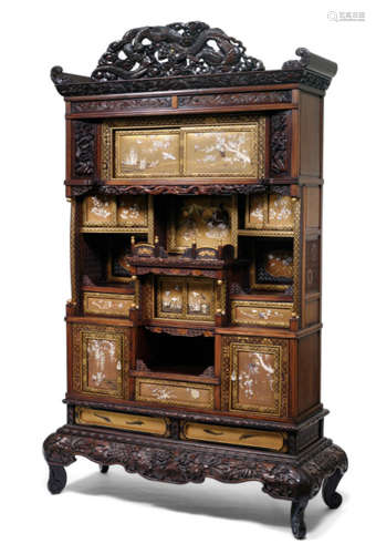 AN ELABORATE SHIBAYAMA DISPLAY CABINET, Japan, Meiji period, separate stand with two decorative lacquer panels depicting fish on gold lacquer ground, the corpus with three drawers, three niches behind sliding doors and two shelves with hinged doors. The door fronts with detailed inlaid decoration of various floral sprays and birds on gold ground. One central panel is decorated with a figural scene of a Samurai kneeling in front of a ruler. Details inlaid in ivory, mother-of-pearl and horn. On top a dragon-carved and pierced pediment - Minor wear, only few inlays replaced