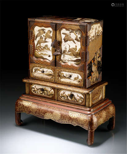 A JEWELLERY BOX IN SHAPE OF A LACQUERED WOOD CABINET, Japan, Meiji period, on a seperate stand with foliage and floral painted gold lacquer decoration, containing 11 drawers and two hinged doors with inlayed ivory panels, depicting various birds and landscapes in gold, red and black lacquer, fine metal mounts with chiselled foliage - Minor wear, partly slightly chipped and some age cracks, only few areas re-painted