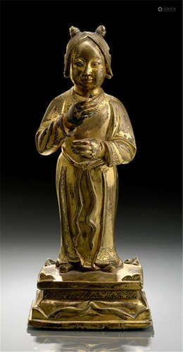 A GILT-BRONZE FIGURE OF A TAOIST IMMORTAL, CHINA, Kangxi period, standing on a rectangular base with both hands in front of the abdomen originally holding a staff, wearing a long robe secured with a ribbon knotted to the front, her face with serene expression and the hair combed with a pair of knots-Property from an old Austrian private collection-Wear, attribute lost