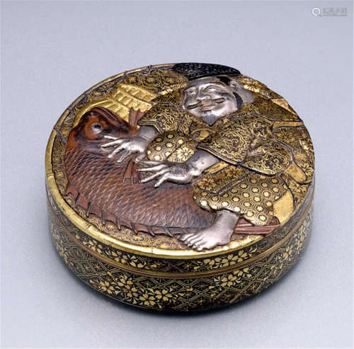 A FINE IRON KOMAI BOX AND COVER, Japan, marked: Inoue Nagamitsu saku, Meiji period, decorated in gold and silver takazogan and nunomezogan, the cover depicting Ebisu wearing a 'kazaori eboshi 'with his red bream, his face well delineated, the surface of the box and cover decorated with various brocade designs including flowers, grape vine, waves and geometric patterns - Some wear