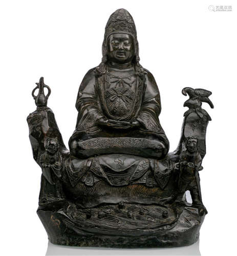A BRONZE MODEL OF GUANYIN ON A ROCK WITH ATTENDANTS