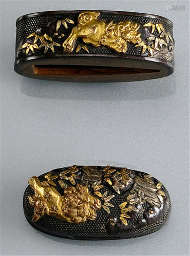 A SHAKUDO FUCHI KASHIRA, Japan, Meiji period, both parts decorated with a shishi among bamboo next to a runnel on nanako ground, details partly gilt - Some wear