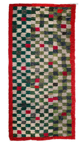 A WOOLEN CARPET WITH A GEOMETRIC RED AND GREEN PATTERN