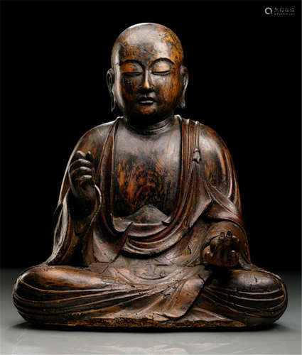 A RARE WOOD FIGURE OF JIZO BOSATSU, Japan, most likely Heian period, seated in relaxed posture with both legs crossed, both hands probably replaced, his right clasped, the left holding the jewel, wearing monk's garment covering both shoulders and falling in pleats over his legs, one section drawn over his left shoulder secured with a string, his face displaying a serene expression with downcast eyes below arched eyebrows that run into his nose-bridge, elongated earlobes and bald head - Property from an old Austrian private collection - Partly small damages due to age, hands possibly replaced