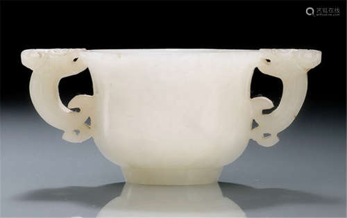 A PALE TRANSLUCENT JADE TWO-HANDLED CUP WITH DRAGON-HEADED LOOP HANDLES