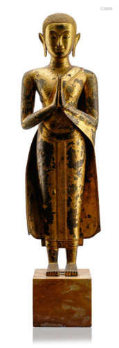 A GILT- AND BLACK-LACQUERED BRONZE FIGURE OF A WORSHIPPER, Thailand, Ayutthaya period, 18th Ct., standing in samabhanga with both hands in anjalimudra, wearing samghati, his face displaying a serene expression with mother-of-pearl inlaid eyes below arched eyebrows and curled hair-dress - Property from an old Bavarian private collection, acquired between 1960 and 1990 - Partly traces of age, mounted