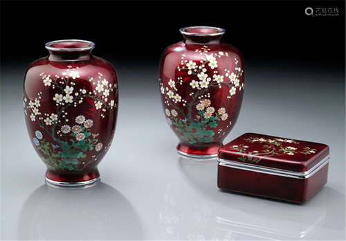 A PAIR OF CLOISONNÉ ENAMEL VASES AND A BOX AND COVER, Japan, Taisho period, each one decorated with cherry trees and Chrysanthemums on red ginbari-ground, with silver rims - Minor wear